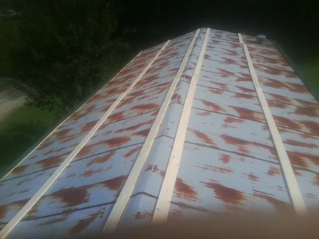 Rusted metal roof panels with new wood purlins before replacement — Storm Damage Roof Repair in Crocheron by Roofing Brothers