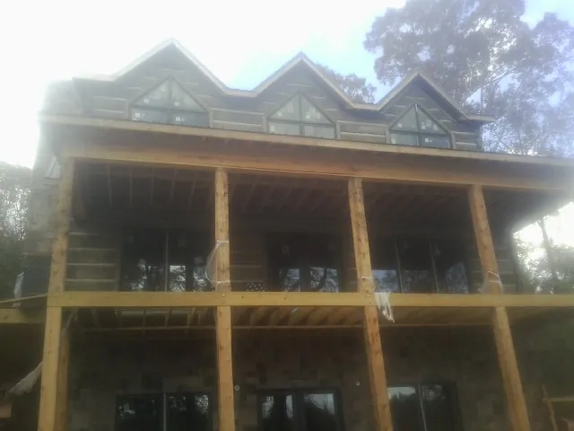 Dormers and porch framing on a large log home under construction in Crocheron