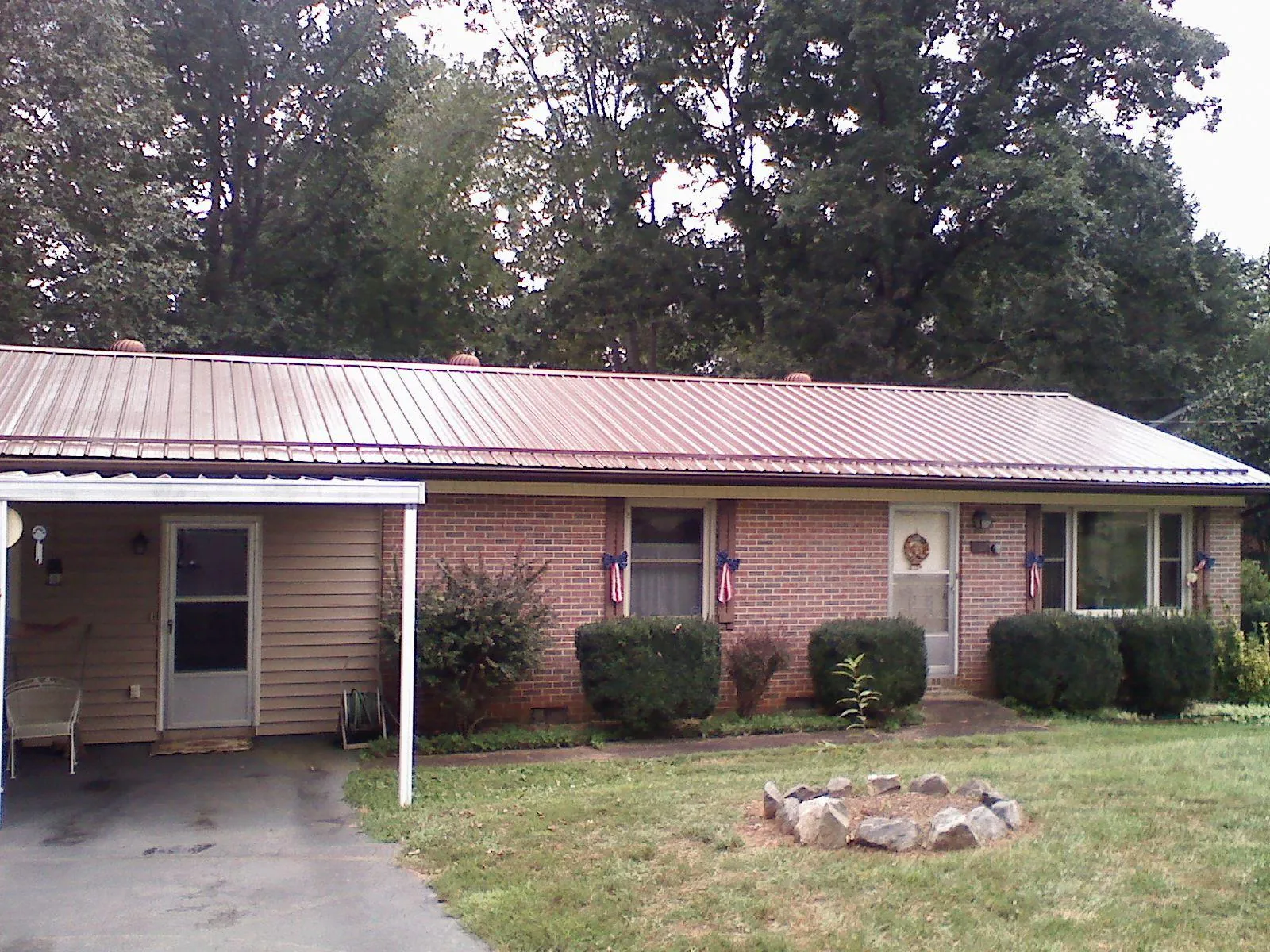 Bronze metal roof and carport on a brick ranch home — Roof Repair work by our crew in Crocheron